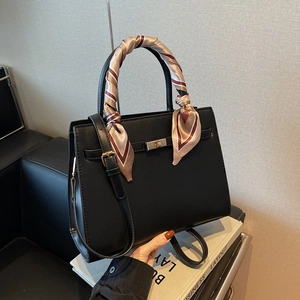 Classic black leather tote bag with gold lock and elegant printed silk scarf handle