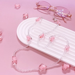 Close-up of pink heart-shaped crystal beads and transparent charms on eyewear chain