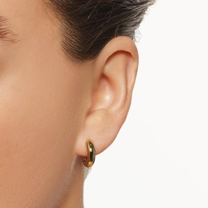 Minimalist S925 sterling silver gold hoop earring worn by a model on plain background