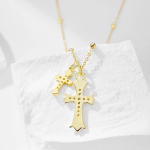 Close-up of gold double cross pendants on S925 sterling silver chain with pearl accents