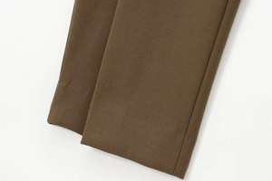 Dettaglio della trama del tessuto marrone scuro e cuciture dell'orlo dei pantaloni autunnali