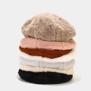 Pile de bérets en fausse fourrure moelleuse dans diverses couleurs douces comme le beige