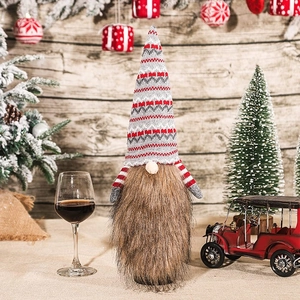 Festive gnome wine bottle cover with knitted hat and plush beard on a holiday table