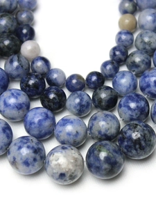 Macro shot of polished blue and white natural sodalite stone beads for DIY jewelry