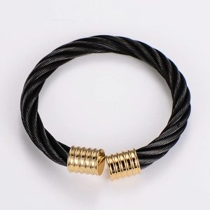 Close-up of black cable wire bracelet with gold-plated threaded end caps on white background