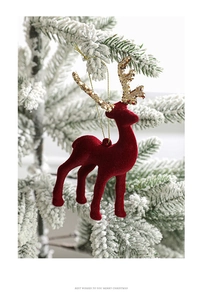 Detail of red flocked Christmas reindeer ornament with gold glitter antlers on a snowy tree