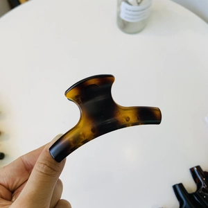 Detailed view of amber tortoise shell hair claw clip with glossy resin finish for women