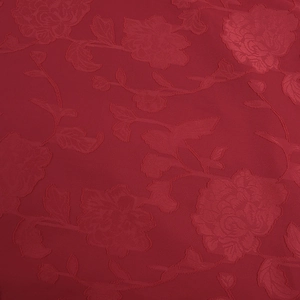 Detailed close-up of dark red jacquard fabric with elegant 3D rose flower patterns