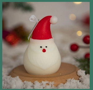 Detailed close-up of a Santa Claus candle on a wooden base with festive pine and snow