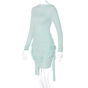 Détail d'une robe vert menthe à manches longues avec fronces et fleur 3D latérale