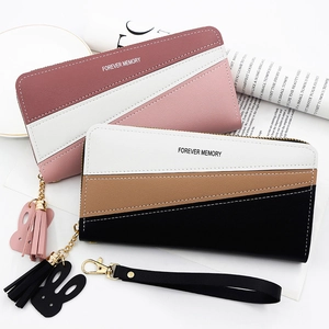 Detail of color-block long wallets with zipper, tassel, and rabbit pendant charms