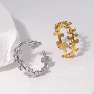 Detailed view of hollow leaf pattern open rings in gold and silver finish on stone