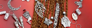Detail of silver alloy dreadlock charms including moon, leaf, and butterfly pendants