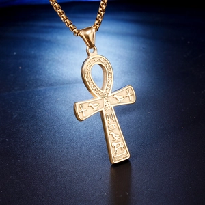 Macro view of golden Ankh pendant with ancient Egyptian hieroglyphic relief carvings