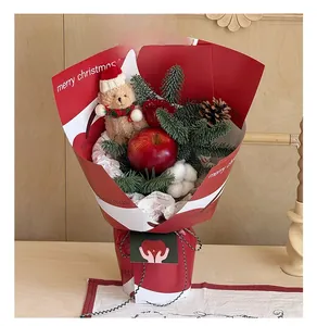 Close-up of Christmas gift box with teddy bear, apple, pine cones and roses