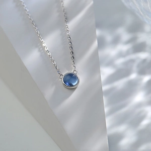 S925 sterling silver necklace with a round ocean blue gemstone pendant on white background