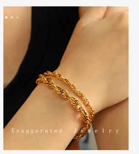 Close-up of double-layer chunky gold twist chain bracelet on wrist with glossy finish