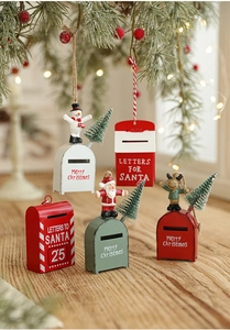 Detail of metal Christmas mailboxes with snowman and Santa figurines on a wooden surface