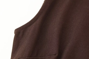 Detail of the high-quality stitching and brown twill fabric on the one-shoulder dress