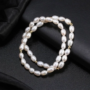 Double-layer natural freshwater pearl bracelet with gold metal beads on black silk background