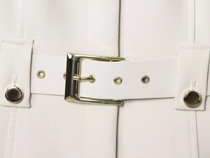 Détail de la veste crème avec boucle de ceinture dorée et texture de tissu premium