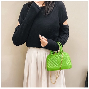 Neon green jelly shell bag featuring V-shaped quilting and gold chain strap detail