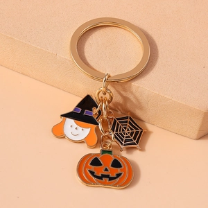 Detail of Halloween keychain with witch, spider web, and pumpkin enamel charms
