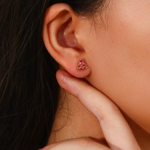 Close-up of a model wearing small pink zircon and gold-plated stainless steel stud earrings