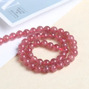 Macro detail of natural strawberry quartz round beads with internal mineral inclusions