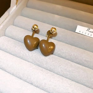 Macro shot of Maillard-style brown heart studs with polished gold accents