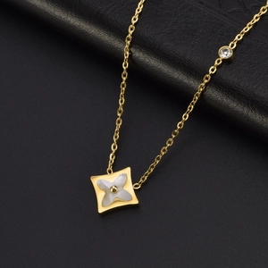 Detail shot of a golden square clover pendant with shell inlay and accent diamond