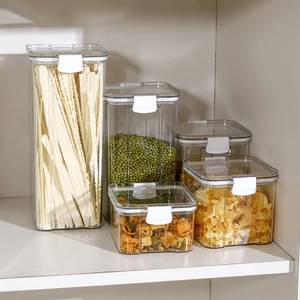 Set of clear plastic food storage containers with airtight white lids on a shelf