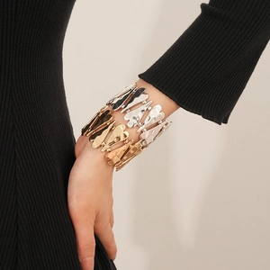 Gros plan d'un bracelet articulé en forme de cœur bicolore porté par un mannequin
