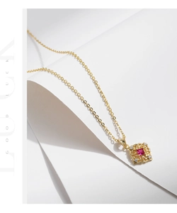 Macro detail of a vintage S925 silver gold-plated necklace with a square ruby pendant