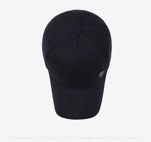 Top view of black cotton baseball cap with six-panel structure and hexagonal metal plaque