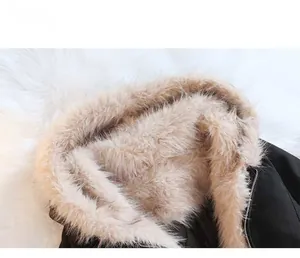 Detail van een zwarte winterparka met een dikke beige faux bontkraag en ritssluiting