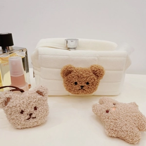 Detail of cream quilted plush bag featuring a 3D brown teddy bear head embroidery