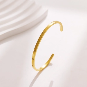 Macro detail of 18k gold-plated cuff bangle featuring five champagne zircon stones