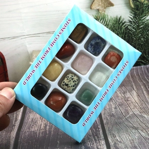 Polished natural stones and crystal specimens in a blue striped gift box packaging