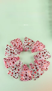 Macro shot of organza drawstring gift bags with shiny red heart patterns in 10-piece sets