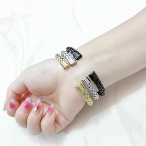 Three braided mesh cuff bracelets in gold, silver and black finish on wrist