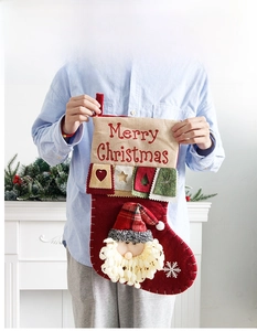 Detail showing red linen Christmas stocking with 3D Santa Claus and Merry Christmas embroidery
