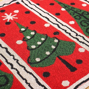 Macro detail of red knitted Christmas placemat with green tree jacquard pattern