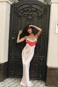 Detail of red bodice with white lace trim and champagne satin skirt on a long dress