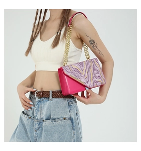 Detailed macro of pink PU leather crossbody bag with marble pattern flap and gold chain