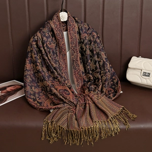 Detail of cashmere-like shawl with paisley patterns, tassels, and luxury accessories