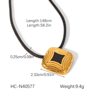 Detail showing 18K gold stainless steel pendant with black enamel on brown braided cord