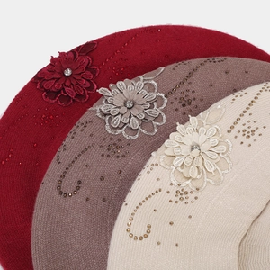 Texture dettagliata di baschi in maglia con fiori 3D e decorazioni in strass lucenti