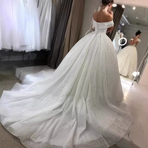 Sparkly white off-shoulder bridal gown with long train and lace-up back detail