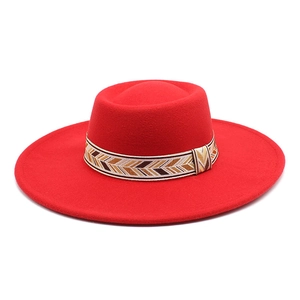 Detail of red wool felt fedora featuring a bohemian woven geometric hatband